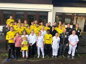 Spillere og trenere fra Start sammen med ansatte og noen av barna fra barneposten.