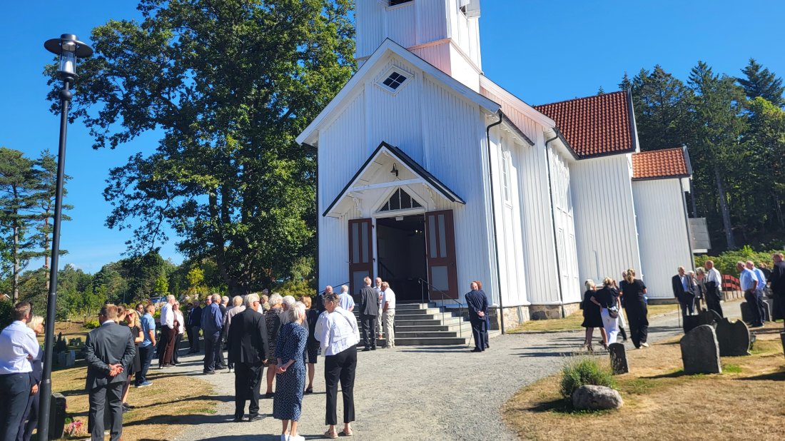 Folk venter utenfor Randesund kirke før begravelsen.