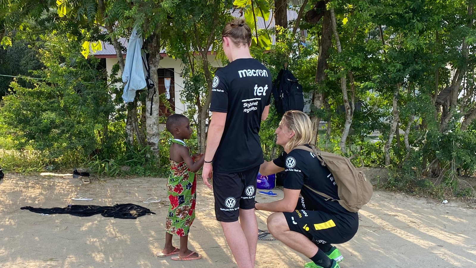 Mikael og Erlend møter en liten gutt på besøk hos en familie i Tanzania. 